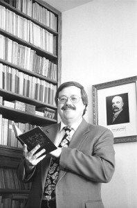 Man holding book in library setting. - 114